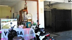 A motorcycle repair shop with a table displaying various tools and parts. - Penginapan Meli (Surabaya)
