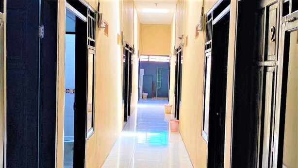 A hallway with doors on both sides, leading to rooms. - Radja Guest House (Makassar)