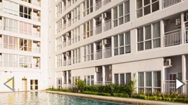 A modern multi-story building with a swimming pool. - Apartment Taman Melati Surabaya by Havana Friends (Surabaya)