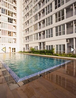 A modern multi-story building with a swimming pool.