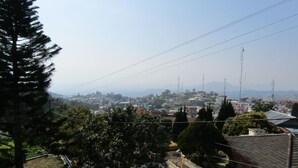 A residential area with houses, a clear sky, and distant mountains.