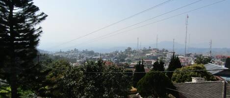 A residential area with houses, a clear sky, and distant mountains.