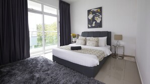 A modern bedroom with a large bed, a side table, a lamp, and a window with curtains. - Desaru Arcadia Villa By Convergence (Bandar Penawar)