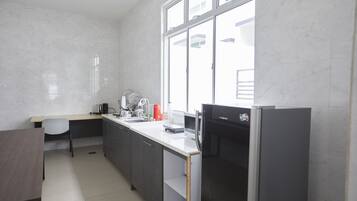 Una cocina moderna con un refrigerador empotrado, un lavamanos y una ventana que proporciona luz natural.