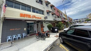 Un hotel anomenat HOTEL Permai, amb l'entrada ben visible i una moto aparcada a l'exterior.