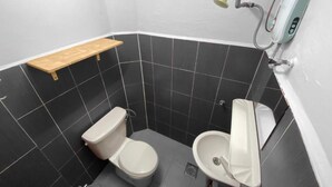 Un bany petit amb vàter, bidet i una prestatgeria.
