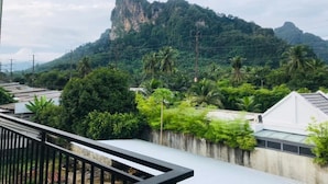 A balcony with a view of a mountain and palm trees. - B.O Best Residence (Phang Nga)