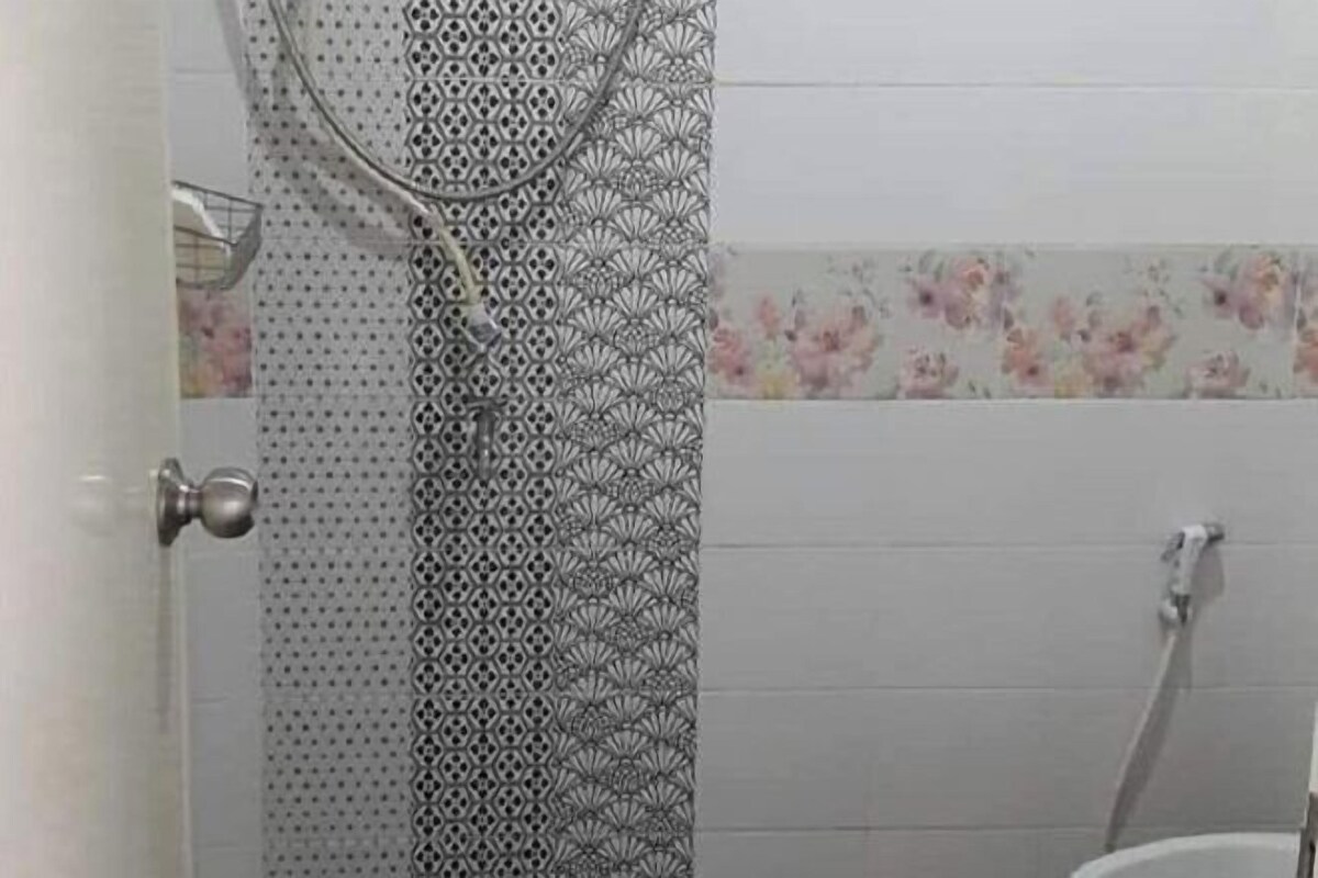 A bathroom with a shower, a toilet, and a sink.