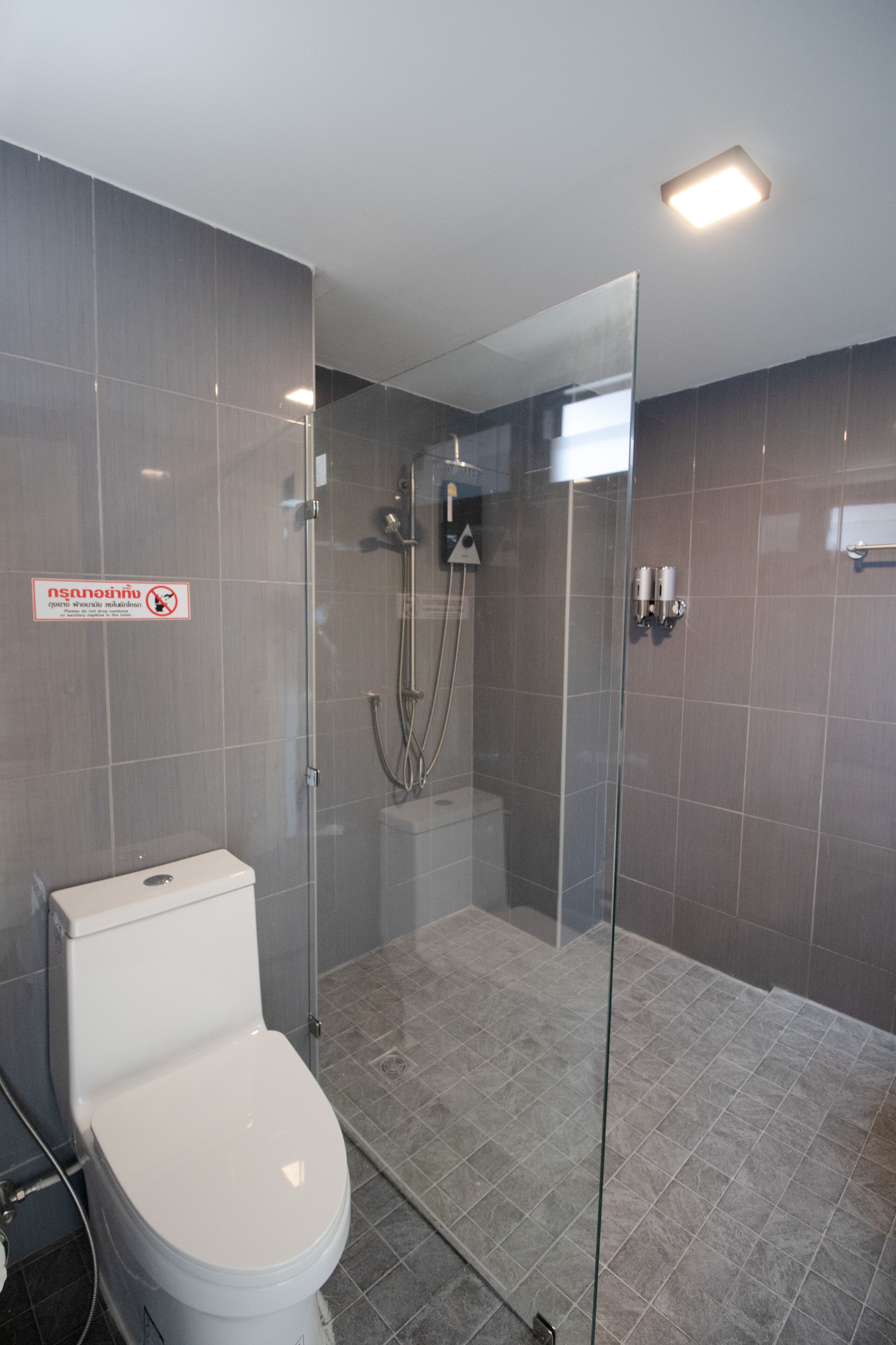 Une salle de bain moderne avec une douche à parois de verre, des toilettes et un lavabo.