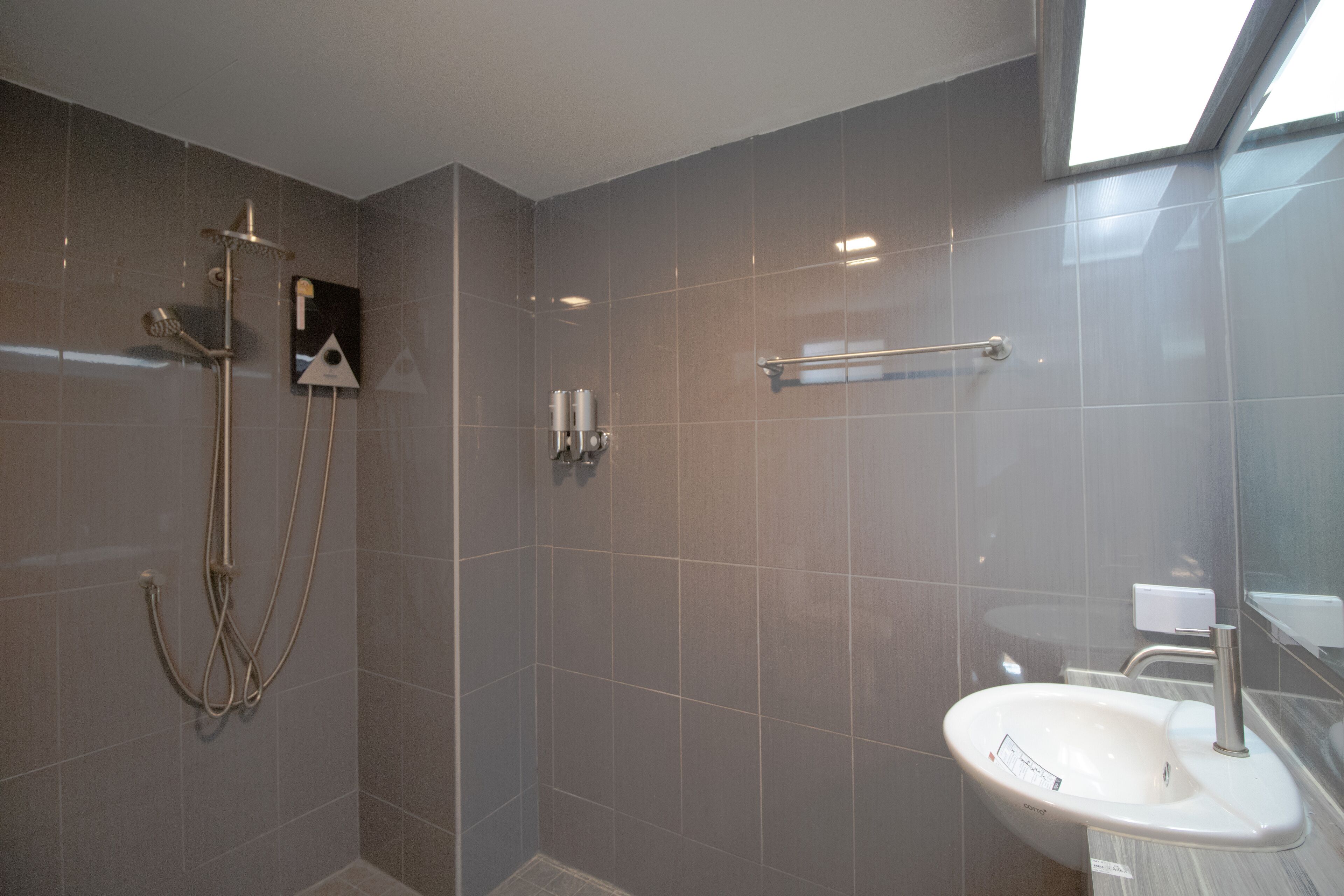 Un baño moderno con ducha, lavamanos y toallero.