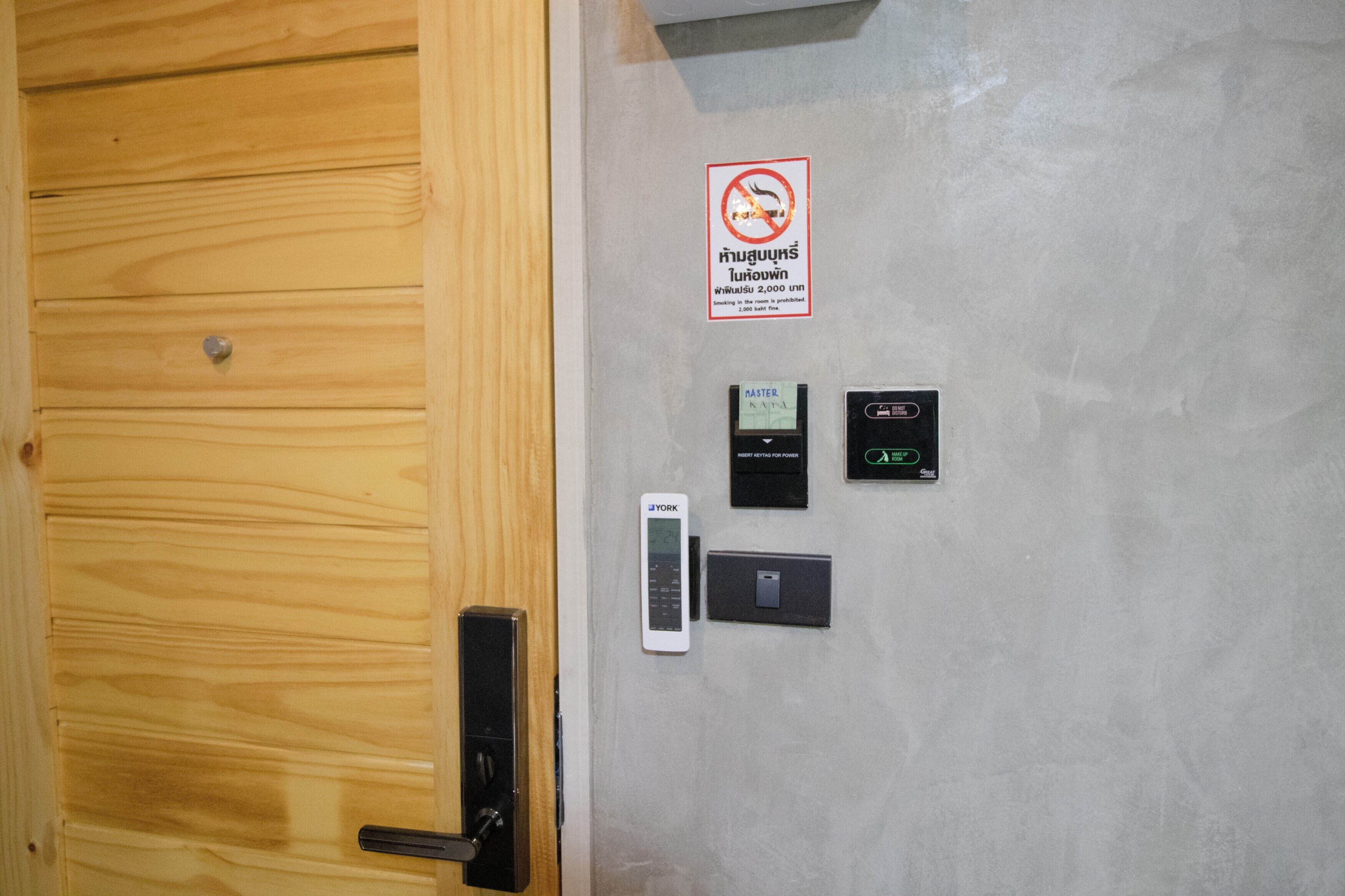 A wooden door with a digital lock, a keypad, and a card reader on a grey wall.