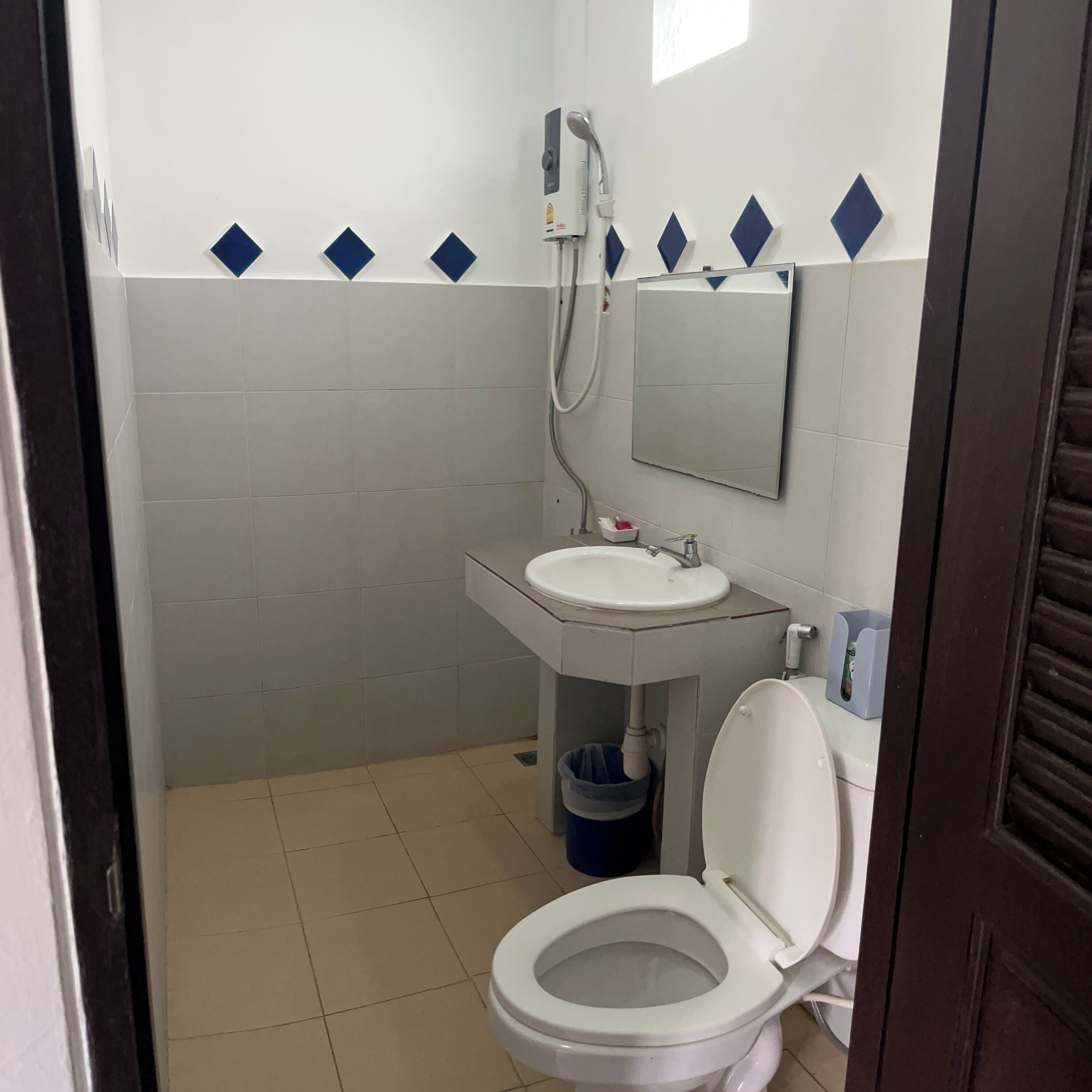 A bathroom with a toilet, sink, and shower.