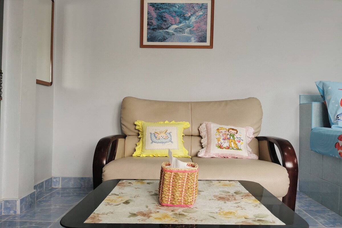 A living room with a sofa, a table, and a framed picture on the wall.