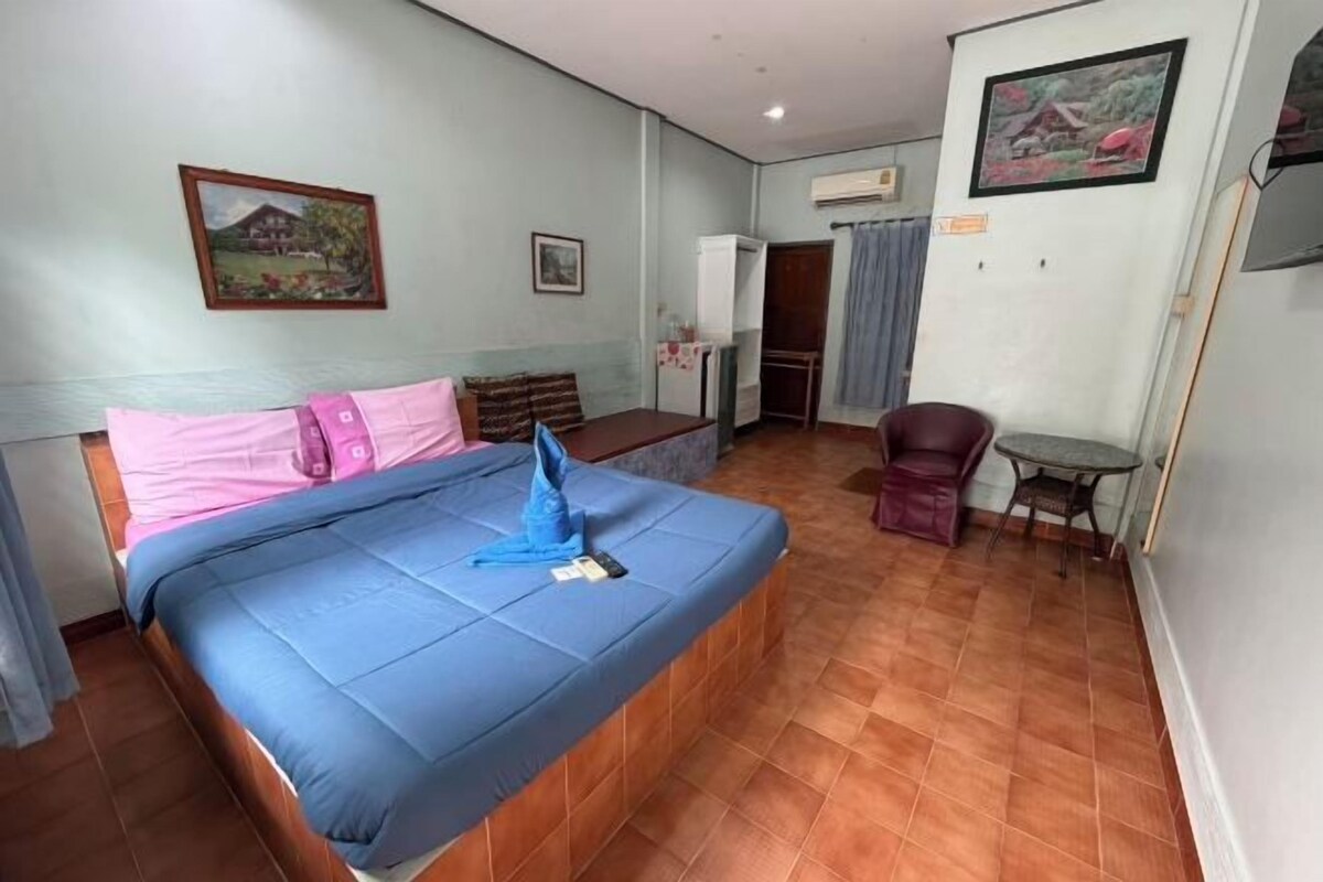 Habitació d'hotel amb llit, escriptori, cadira i taula petita.