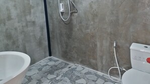 Ein Badezimmer mit Badewanne, Toilette und Dusche.
