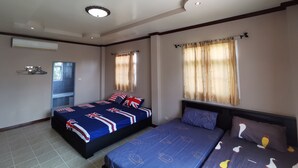A bedroom with two beds, a window with curtains, a ceiling light, and an air conditioning unit. - Lek Homestay (Si Racha)