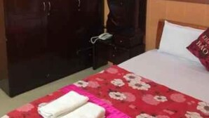 Un dormitorio con cama, armario y una lámpara fijada a la pared.