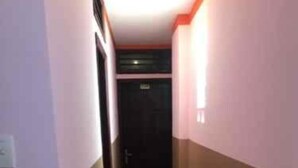 Un pasillo estrecho con una puerta al final.