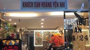 The entrance of a hotel with a sign reading "KHÃCH SAN HOANG YEN NHI". - Hoang Yen Nhi Hotel (Ho Chi Minh City)