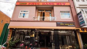 A hotel named 'PHÍC DÂNG HUY' with a modern facade, large windows, and a visible entrance. - Phuc Dang Huy Hotel (Xuan Huong - Da Lat)