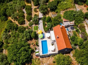 An aerial view of a property with a swimming pool, outdoor seating, and lush greenery. - House Kocan (Konavle)
