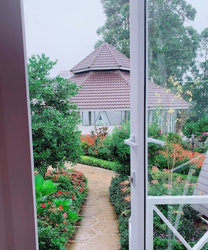 Un sentier de jardin menant à une maison dont le toit est recouvert de tuiles.