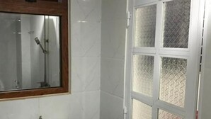 Ein Badezimmer mit einem weißen Waschbecken, einem Holzkosmetikschrank und einer Tür aus Sandglas.