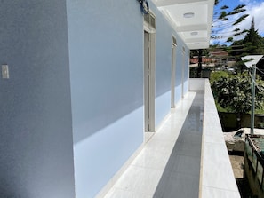 Un couloir au sol carrelé et aux murs bleu clair.