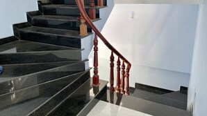 Un escalier en colimaçon avec des marches noires et des balustrades en bois.