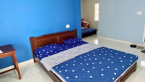 Une chambre à coucher avec un lit, une table de chevet en bois et un mur bleu.