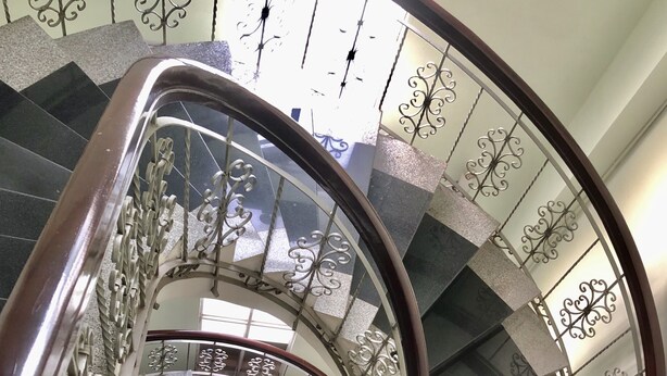 A spiral staircase with ornate metal railings and a dark wooden handrail. - Thang Loi Hotel (Ho Chi Minh City)