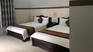 A hotel room with two beds, a nightstand, a lamp, and a curtain. - Mai Vuong Thuy Hotel (Ho Chi Minh City)