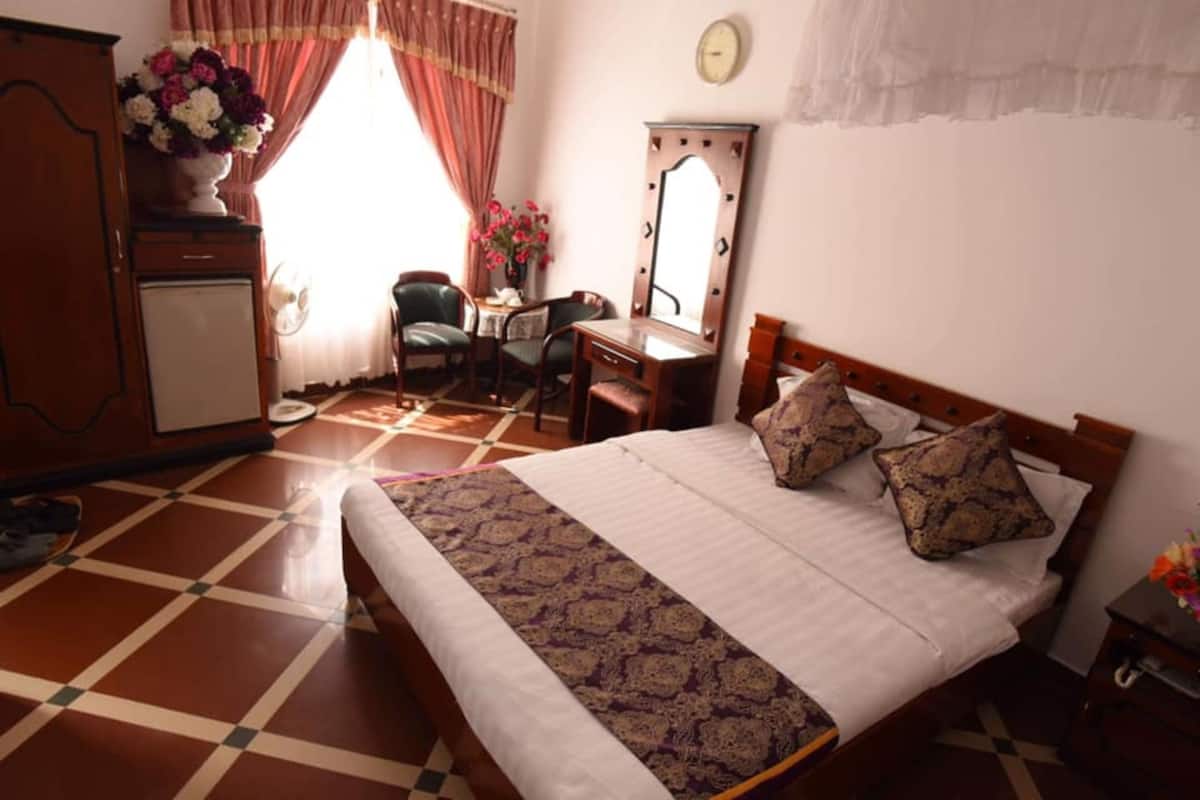 A bedroom with a bed, a dresser, a desk, and a chair.