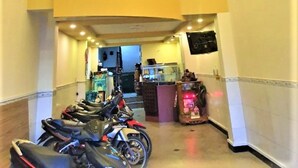 Eine Diele mit einer Reihe abgestellter Motorräder, einem Empfangsbereich und gerahmten Bildern an der Wand.