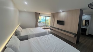 A hotel room with two beds, a TV, a desk, and a balcony with a view. - Thao Trang Hotel Dong Hoi (Dong Hoi)