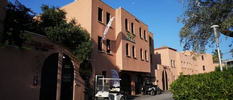 A building with a sign for 'R5 Hotel' and a golf cart parked in front.