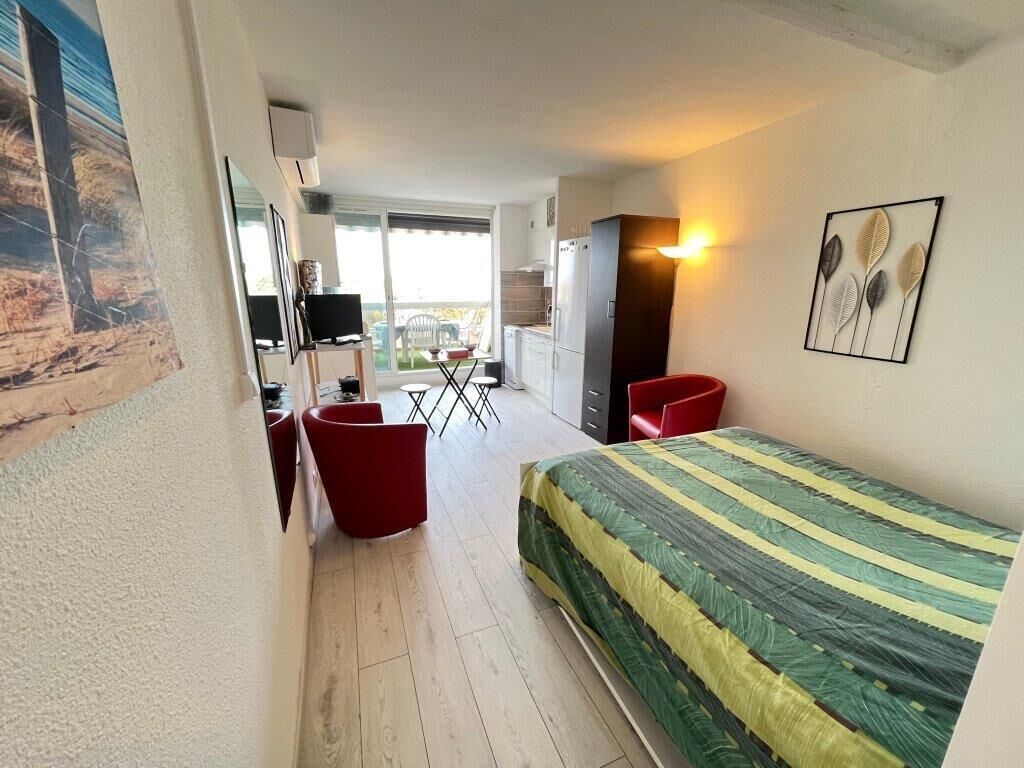 Une chambre d’hôtel comprenant un lit, un bureau avec une chaise, une petite table et un réfrigérateur.