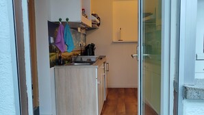 A compact kitchen with wooden flooring, a built-in sink, and a small countertop.