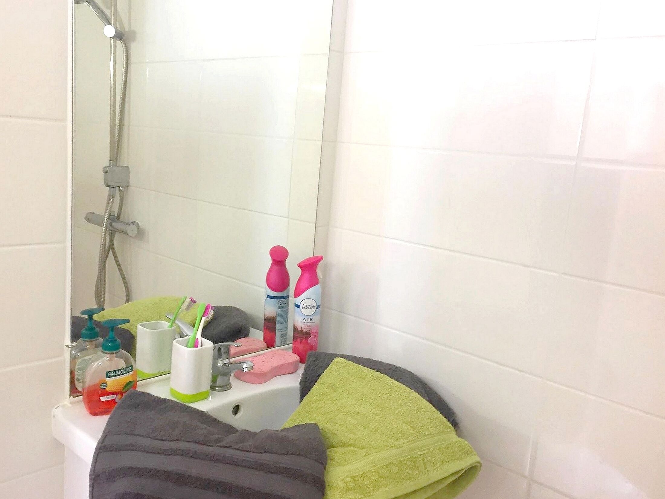 A bathroom with a sink, mirror, and toiletries.