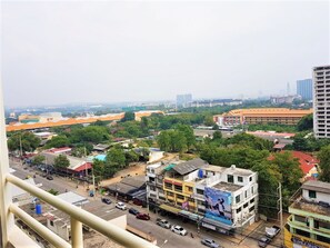 A multi-story building with a commercial ground floor, surrounded by greenery and other buildings. - 11th Floor Studio at View Talay 1 (Pattaya)