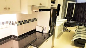 A compact kitchen with a toaster, kettle, and a black countertop. - 11th Floor Studio at View Talay 1 (Pattaya)