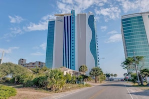 A modern hotel with a prominent vertical design, featuring a central tower and a curved building.