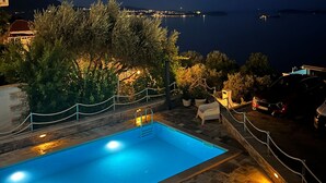 Una piscina con vista al mar de noche.