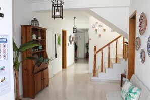 A spacious hallway with a wooden staircase, a wooden cabinet with plants, and a wall-mounted light fixture. - Villa 4+1 persons, near beach and Albufeira center, WiFi, BBQ, A/C, swimming pool (Albufeira)