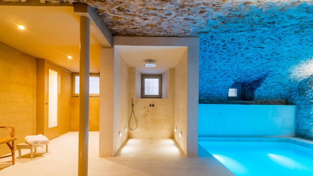 A modern bathroom with a bathtub, a shower area, and a small window.