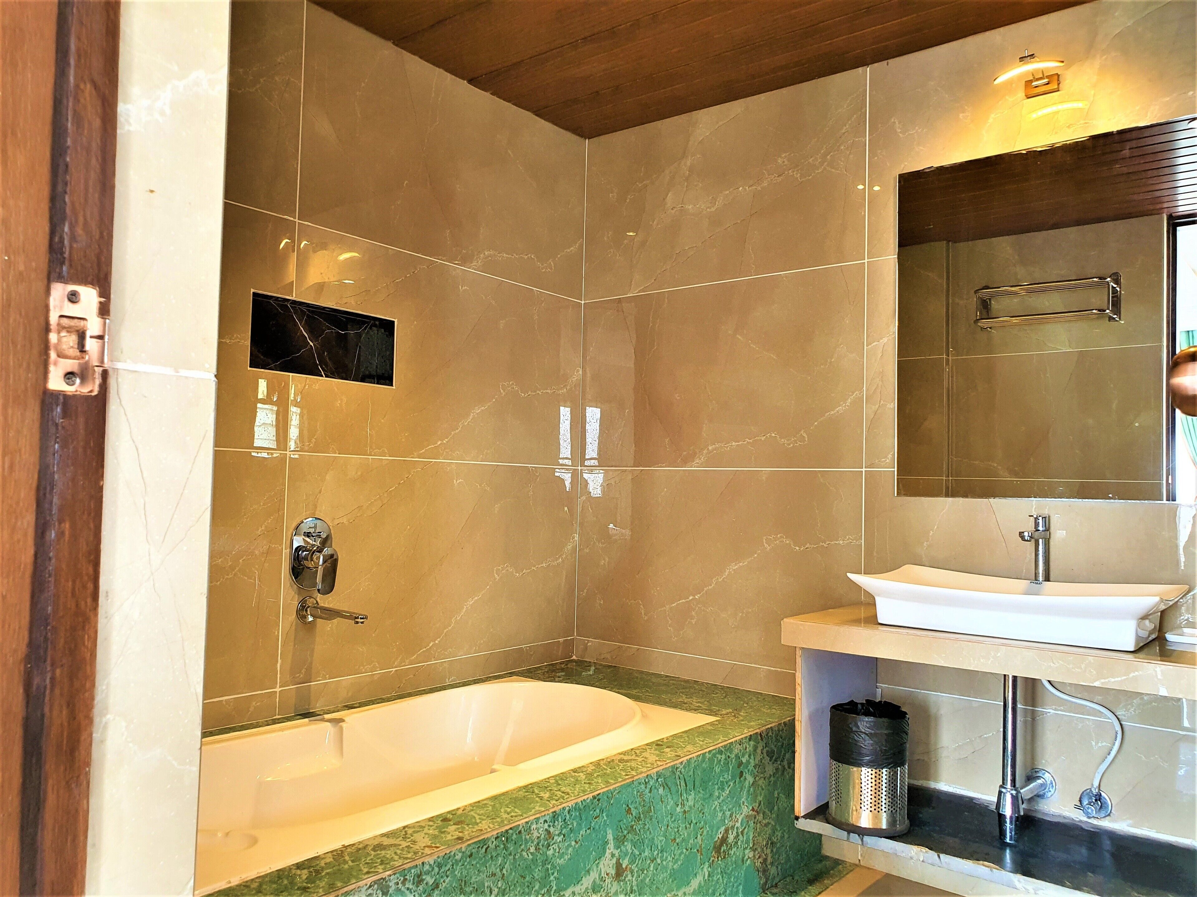 A bathroom with a bathtub, a sink, and a mirror.