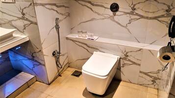 A bathroom with a toilet, a shower, and a sink.