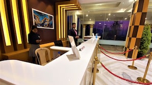 A hotel reception area with a long counter, a reception desk, and a sign that reads "Check-in". - VITS Excellensea Karde Beach (Dapoli)