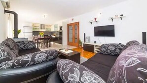 Una sala moderna con un conjunto de sofá, una mesa de centro y un televisor de pantalla plana montado en la pared.