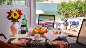 A table with a book, glasses, and fruit.